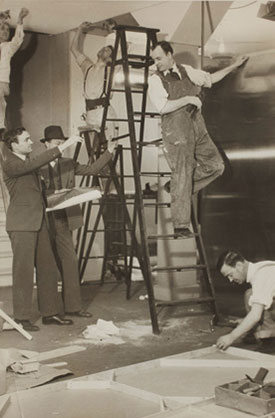 Johnson (left) and Ruhtenberg (in hat), directing the installation of Machine Art, 1934. | © MUSEUM OF MODERN ART/LICENSED BY SCALA/ART RESOURCE