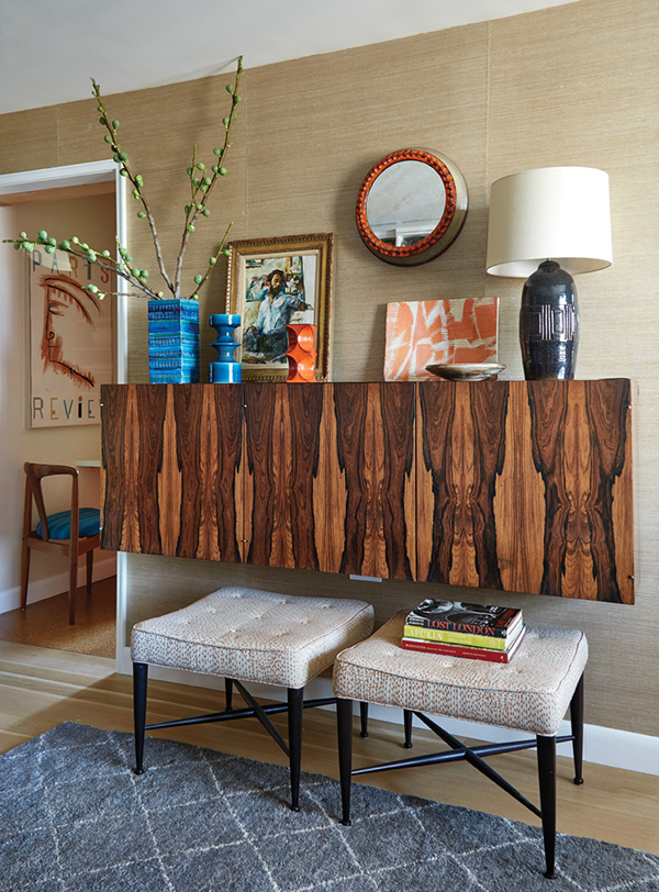 The 1960s Brazilian rosewood hanging bar cabinet is unattributed. To add a pop of color when it is open—and to ensure durability—Clem had the interior lined with lacquer-red laminate. Below are Thebes stools by Edward Wormley for Dunbar. Above hangs the ceramic mirror, c. 1966, by the father of one of the owners. The blue vases on the cabinet are by Bitossi. | Photography by MARK ROSKAMS