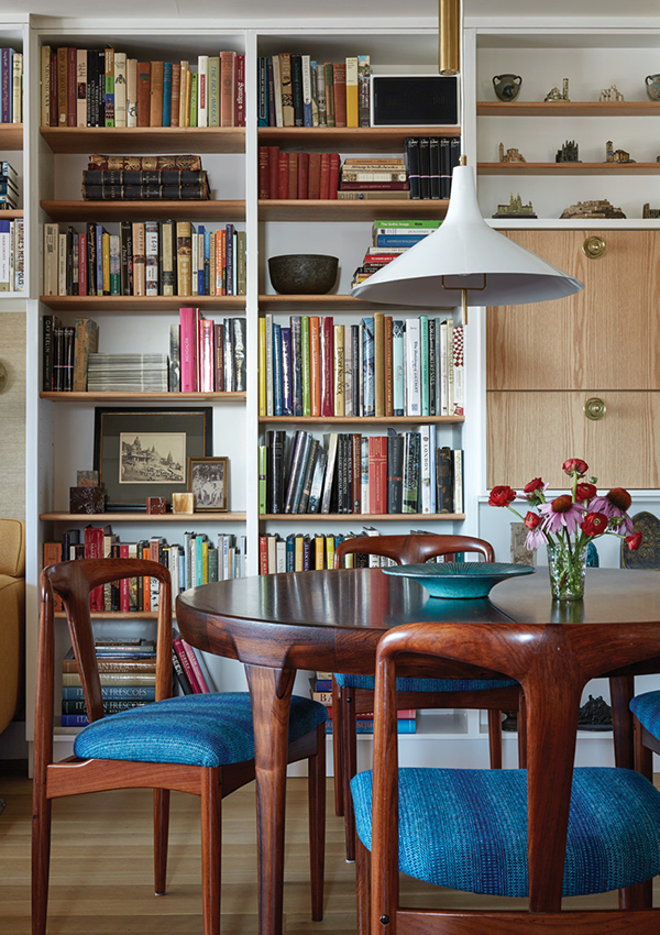 Like much of the furniture, the rosewood dining table and chairs were both found online: the table, by Ib Kofod Larsen, c. 1950s, in Denmark; the chairs by Johannes Andersen, 1950s, in Arizona. The pendant light is attributed to Paavo Tynell. To hide an irregularity in the wall at one end of the shelving, Clem designed a drop-down cabinet in white oak—“that idea was taken from Juhl’s house too,” he says. | Photography by MARK ROSKAMS