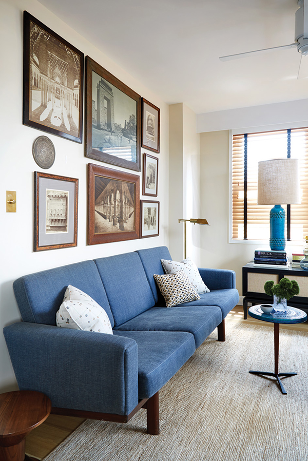 An arrangement of prints and albumen photographs reflecting the owners’ travels hangs above a Wegner sofa in the office. In front of the sofa is a Bitossi side table, 1950s. The lamp on the cabinet under the window, by Maurice Bailey for Monteverdi- Young, is also attributed to Bitossi. | Photography by MARK ROSKAMS