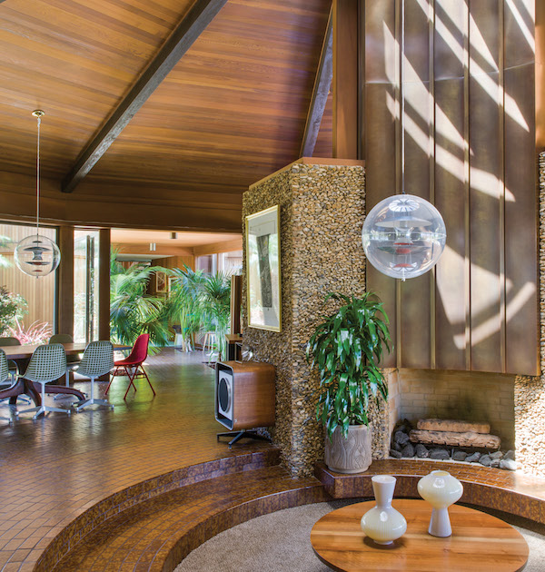 The living wing of the Encino, California, house feels at once spacious and intimate with its open floor plan and expansive windows,and it is the perfect stage for Peter and Shannon Loughrey’s mid-century design pieces—including a George Nakashima coffee table,a Charles Eames speaker, an Arthur Espenet Carpenter dining table, and Eames dining chairs (two were wrapped in red by artist Tanya Aguiñiga). | Photography by Stephan Julliard