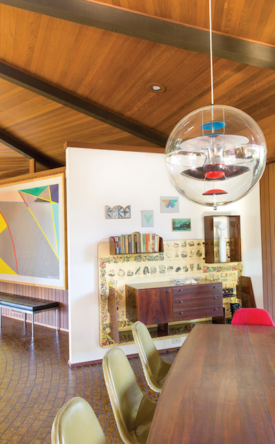 A Roy Lichtenstein print from the Imperfect Series hangs to the left of the dining area, where Peter has installed one of two Vernon Panton globes he had purchased at the Copenhagen Modernism fair about 2001; they had been sitting in a box in a warehouse until the Loughreys moved into this house. | Photography by Stephan Julliard