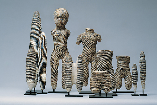 This group of porcelain torsos and staffs was made 1976–1981. Shaped like ancient, broken, or worn-away statuary, the striped figures resemble burial pieces, while their surfaces also suggest the ridged texture and markings of seashells. | D. JAMES DEE PHOTO