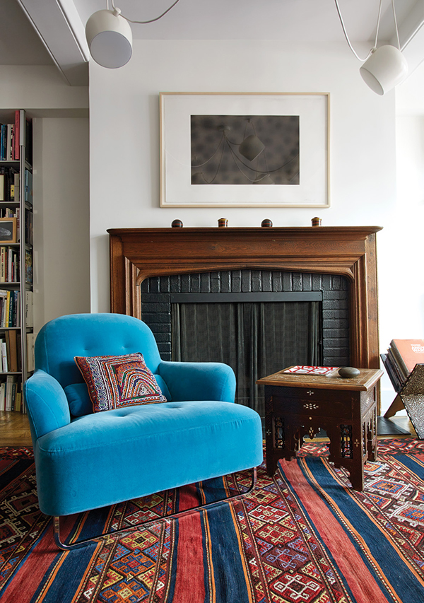 Bright blue armchairs, also from Ligne Roset, flank the wood-burning fireplace. The vintage Murat kilim rug is from Double Knot in Tribeca. Above the fireplace is Carbon Drawing No. 9 by Norman Mooney which the artist created with soot from an acetylene torch. | Photography by MARK ROSKAMS