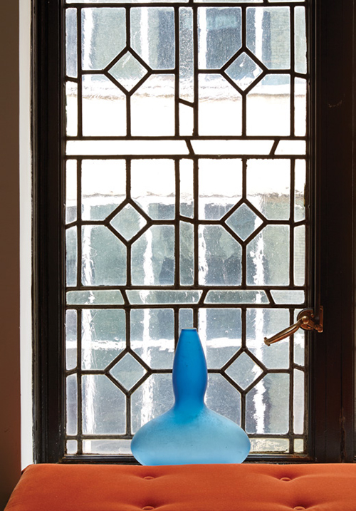 A detail of the leaded glass windows in the living room, with a vessel made by the B Team for Littman when he was associate director at UrbanGlass. | Photography by MARK ROSKAMS