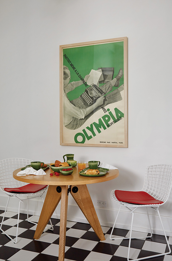 Littman and Vander Weg usually take their meals at the Jean Prouvé table, with Harry Bertoia chairs for Knoll. The Frosty Pine dinnerware by Tamac Pottery, from their extensive collection, is one of their favorite sets. The vintage Olympia typewriter poster by Francis Bernard was the first artwork Littman purchased when he began collecting. | Photography by MARK ROSKAMS