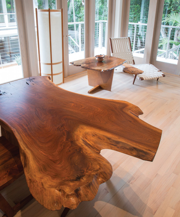 The Minguren I end table and Long chair with an English oak burl arm are nestled in a corner of the study, along with two additional pieces by George Nakashima, a Cross-Legged desk, and a Kent Hall lamp with a walnut-root frame and rice- paper shade.